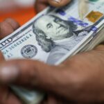 Dólar opera em alta com mercado reagindo a acordo entre EUA e China sobre tarifas